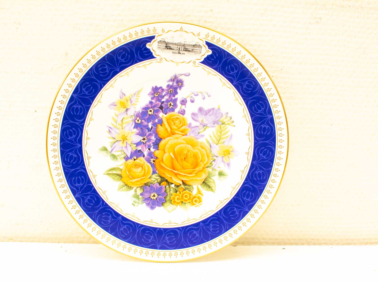 Vibrant floral porcelain plate with yellow roses, cobalt blue border, and gold accents.