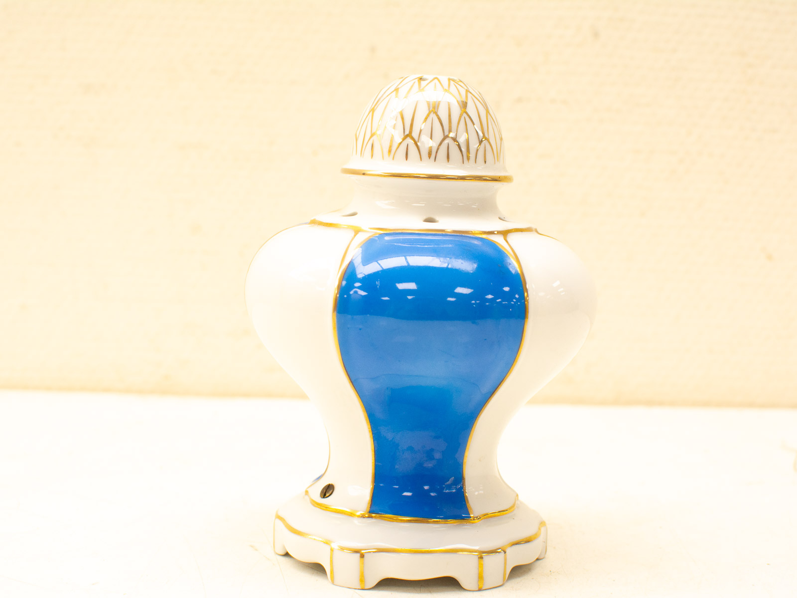 Elegant ceramic vase with blue panel and gold accents, perfect for decorative display.