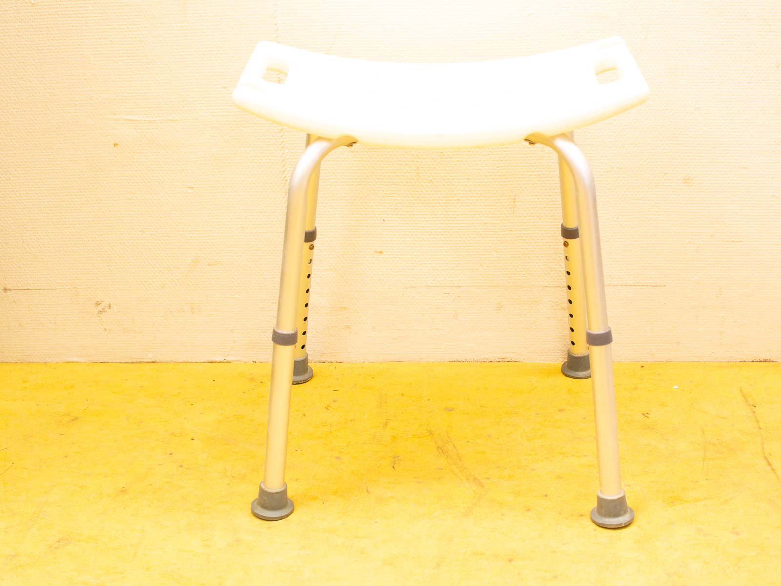 Adjustable white plastic stool with aluminum legs, perfect for versatile and practical seating solutions.