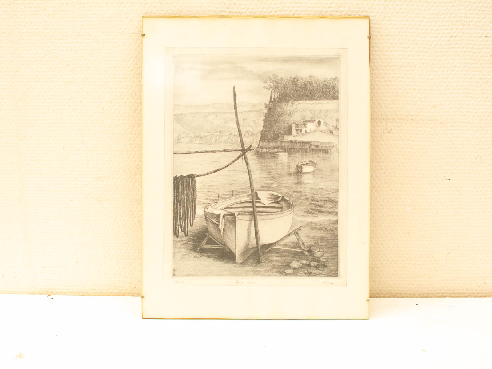 Tranquil black-and-white coastal scene with a moored boat and gentle hills in the background.