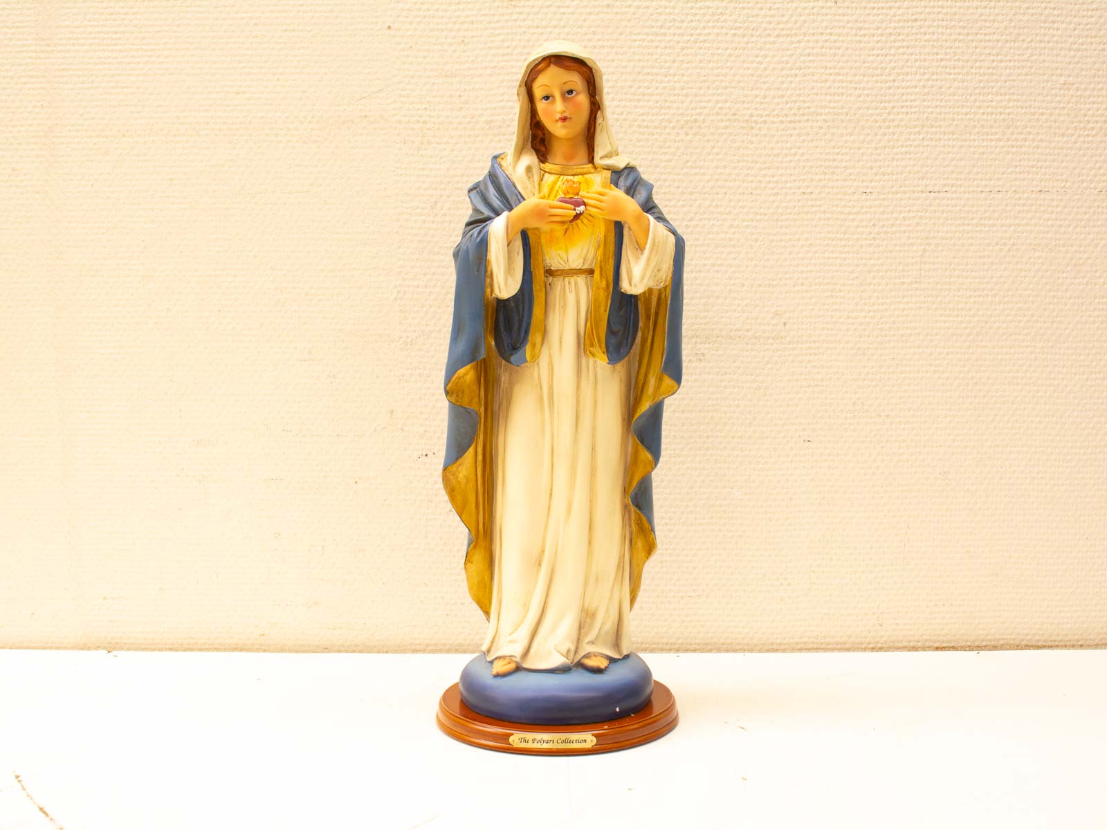 Elegant statue of Saint Mary with Sacred Heart, symbolizing peace and love.