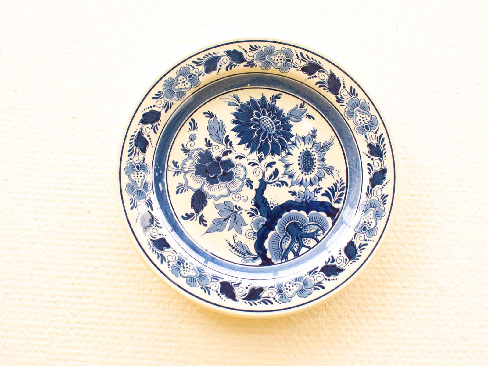 Elegant vintage ceramic plate with intricate deep blue floral design, perfect for decor and tableware.