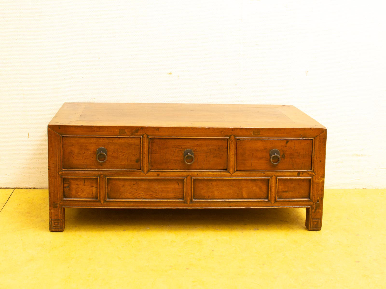 Rustic wooden coffee table with three drawers, warm finish, and inviting charm for any space.