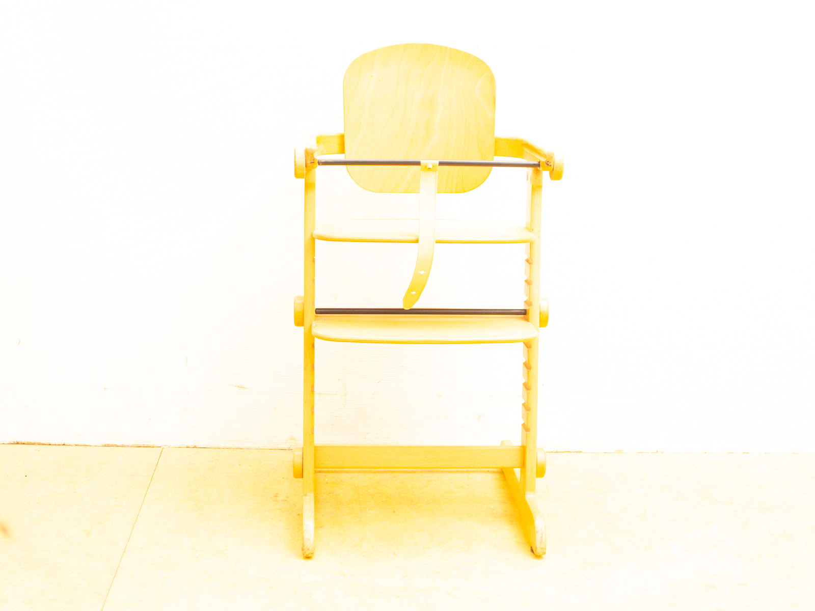 Stylish wooden high chair for kids with storage shelves and safety features for modern homes.