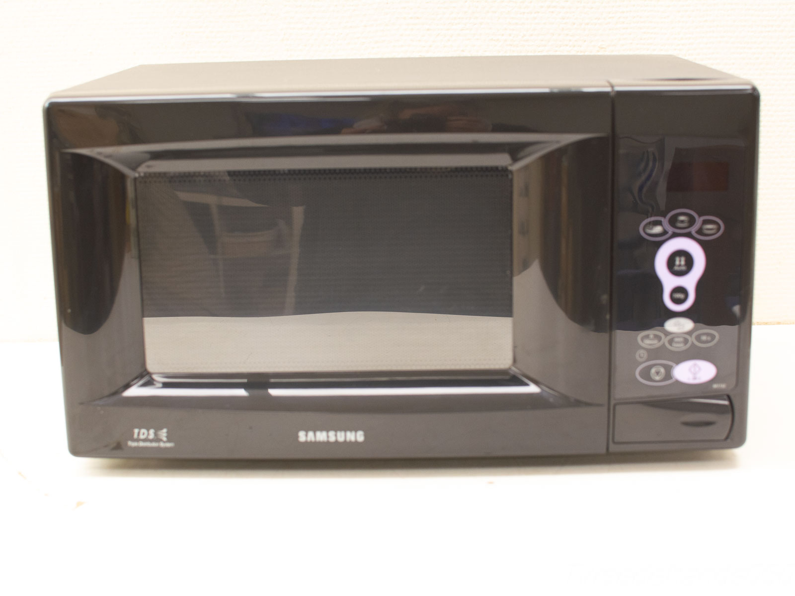 Sleek Samsung microwave with glossy black finish and advanced even heating technology for efficient cooking.