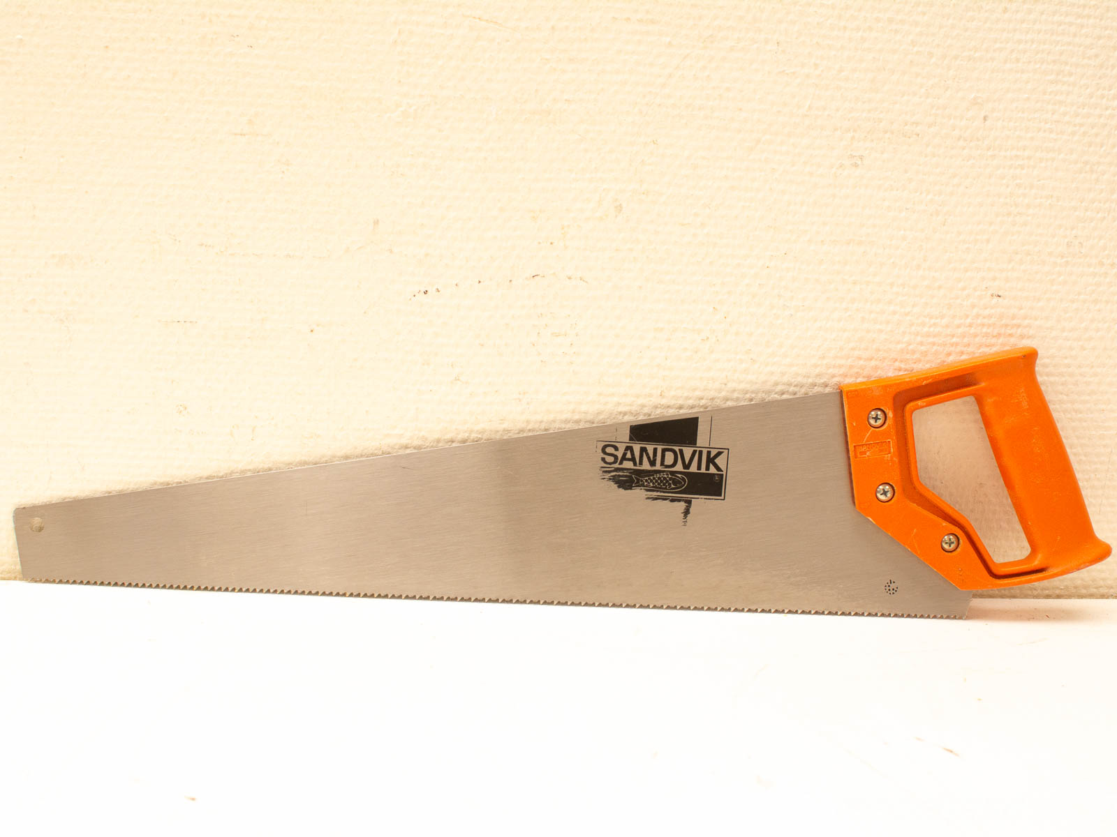 Powerful Sandvik handsaw with ergonomic orange handle, perfect for woodworking projects and DIY tasks.