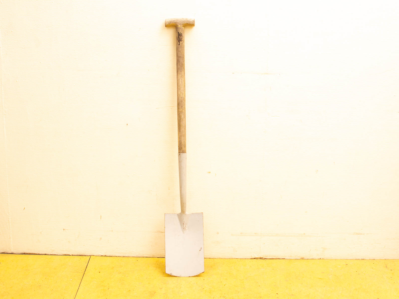 Classic vintage garden shovel with wooden handle and white metal spade, perfect for outdoor tasks.