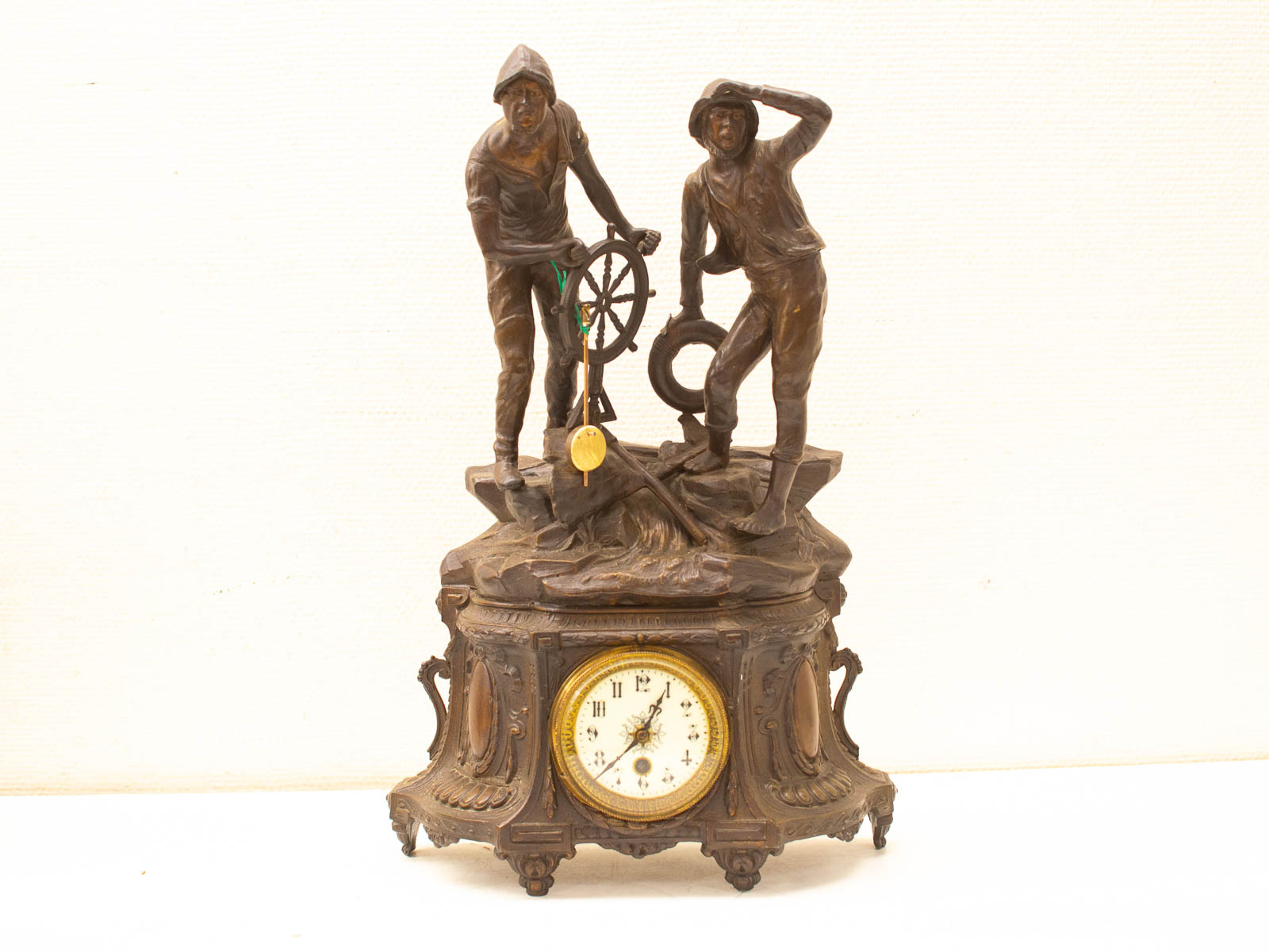 Antique maritime clock with intricate figures, Roman numerals, and vintage craftsmanship. Perfect for collectors.