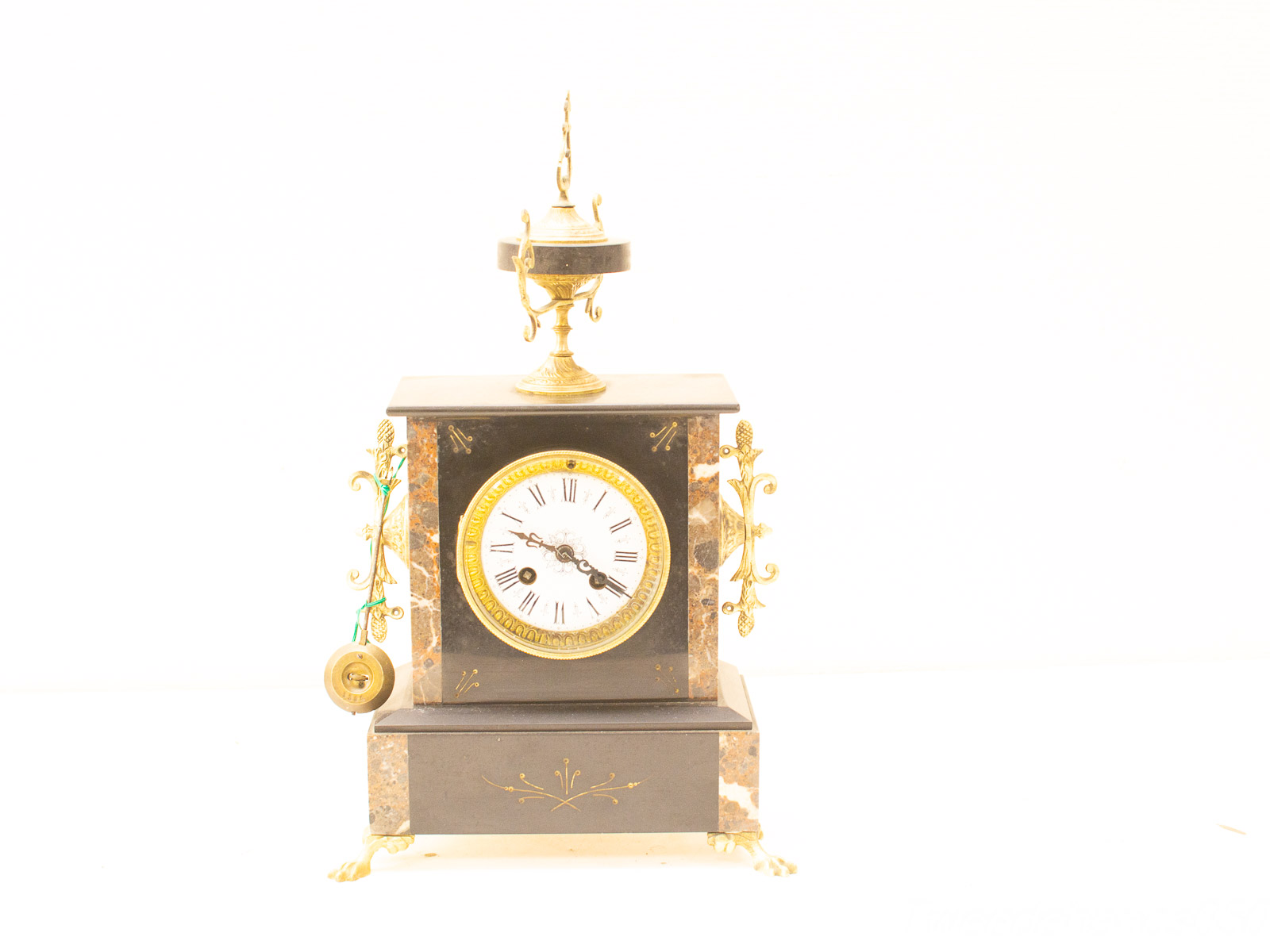 Antique marble clock with gold accents and pendulum, perfect for vintage decor enthusiasts.