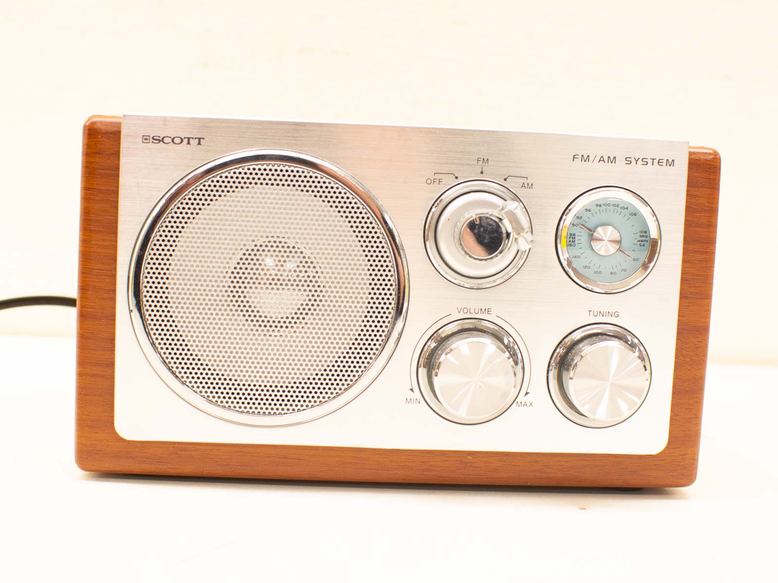 Elegant vintage FM/AM radio with wooden casing and stylish metallic accents, perfect for collectors.