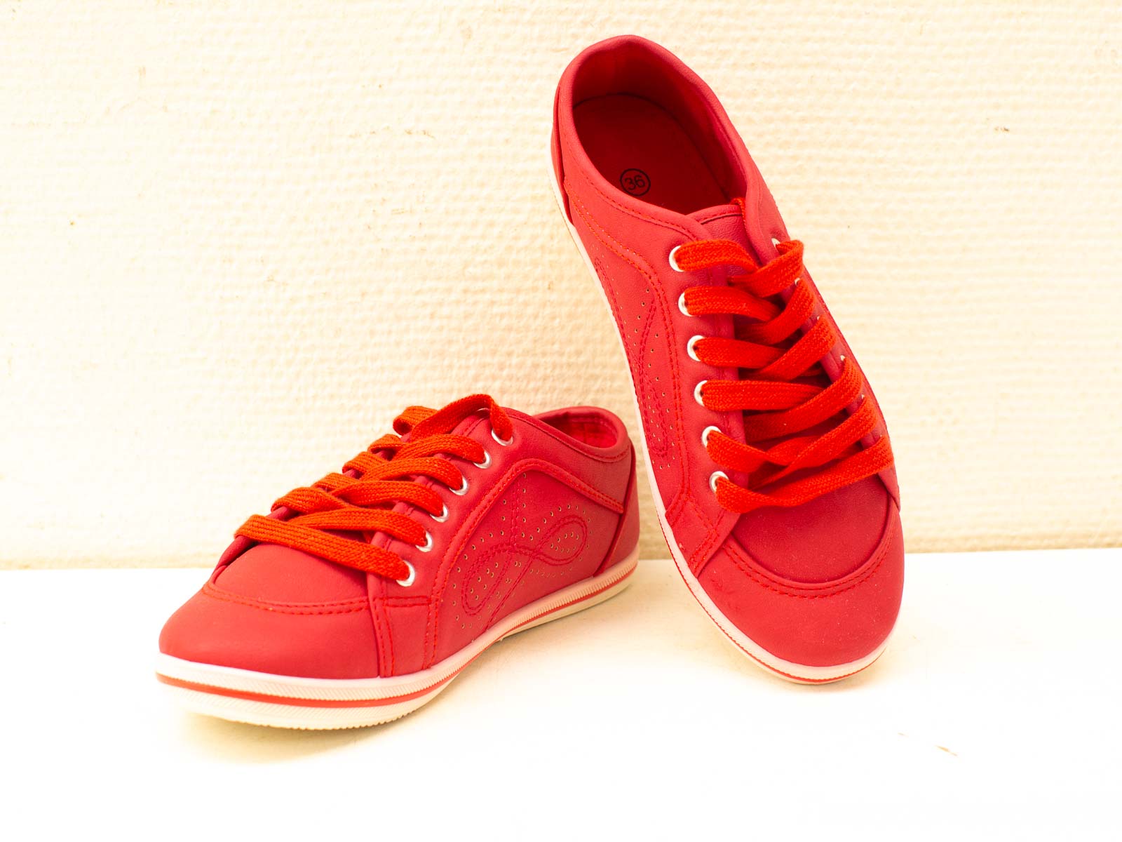 Vibrant red sneakers with white soles for a stylish and sporty everyday look.