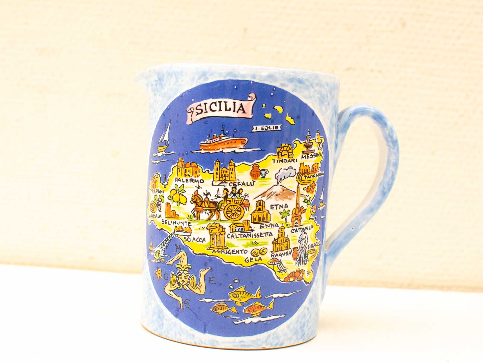 Colorful Sicilian ceramic jug featuring a detailed map and whimsical maritime illustrations.