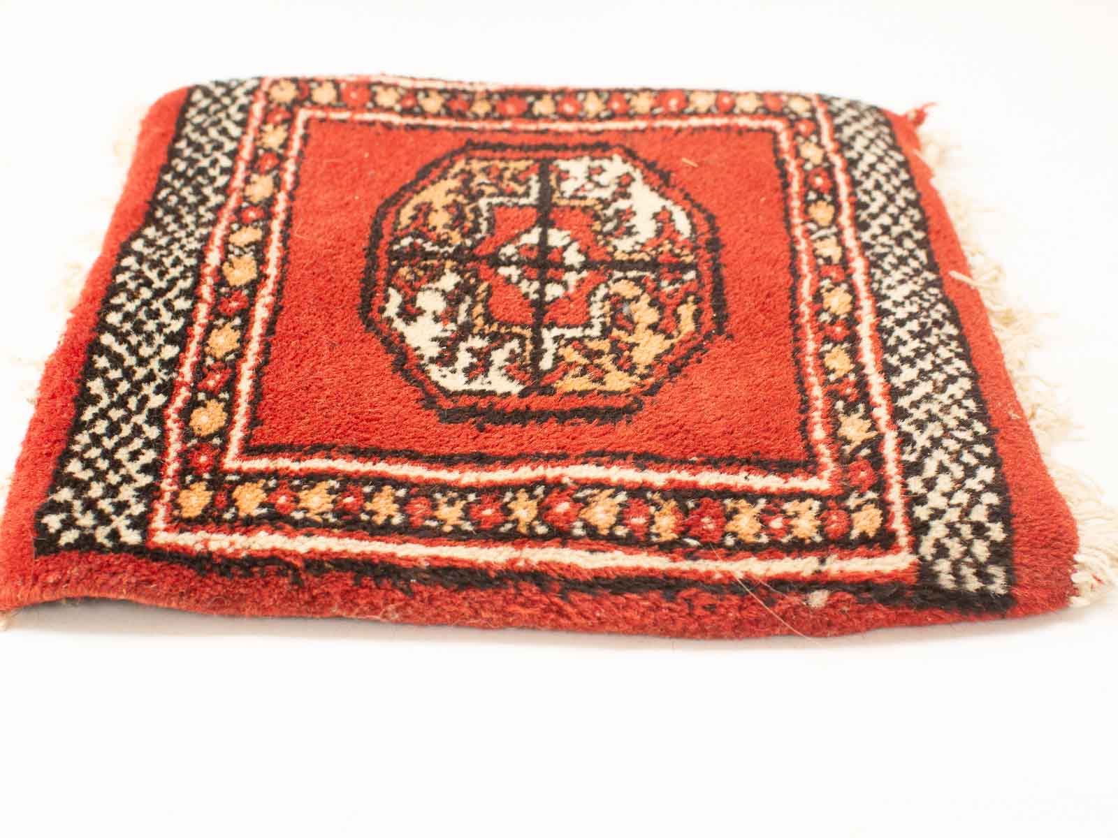 Handmade vintage geometric rug in deep red with intricate patterns and plush texture.