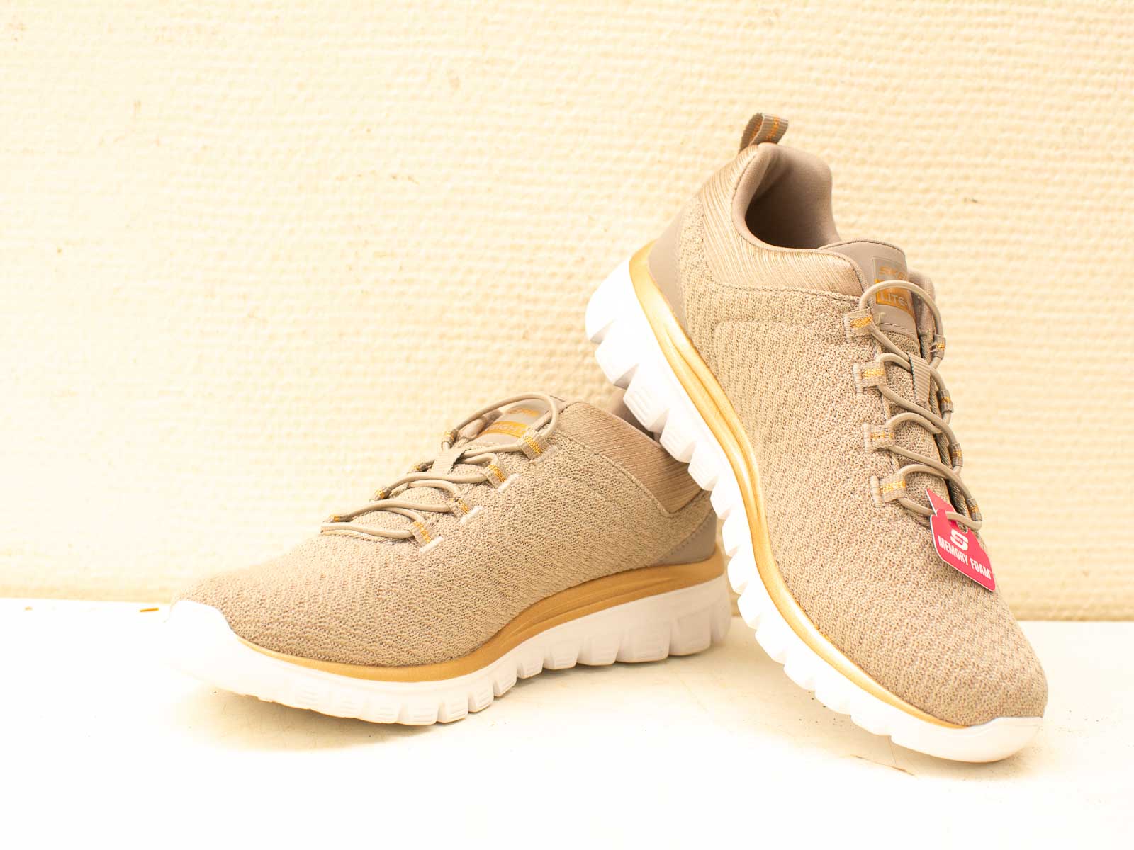 Stylish beige athletic shoes with a white sole for comfort and modern versatility.