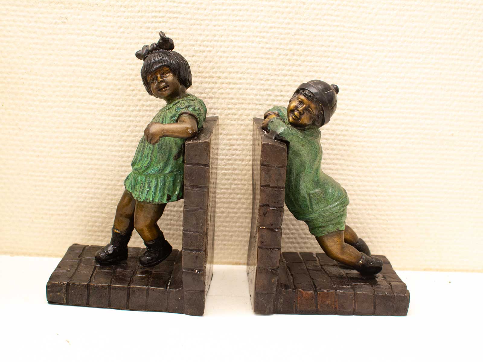 Whimsical green vintage bookends featuring playful children, perfect for any book lovers decor.