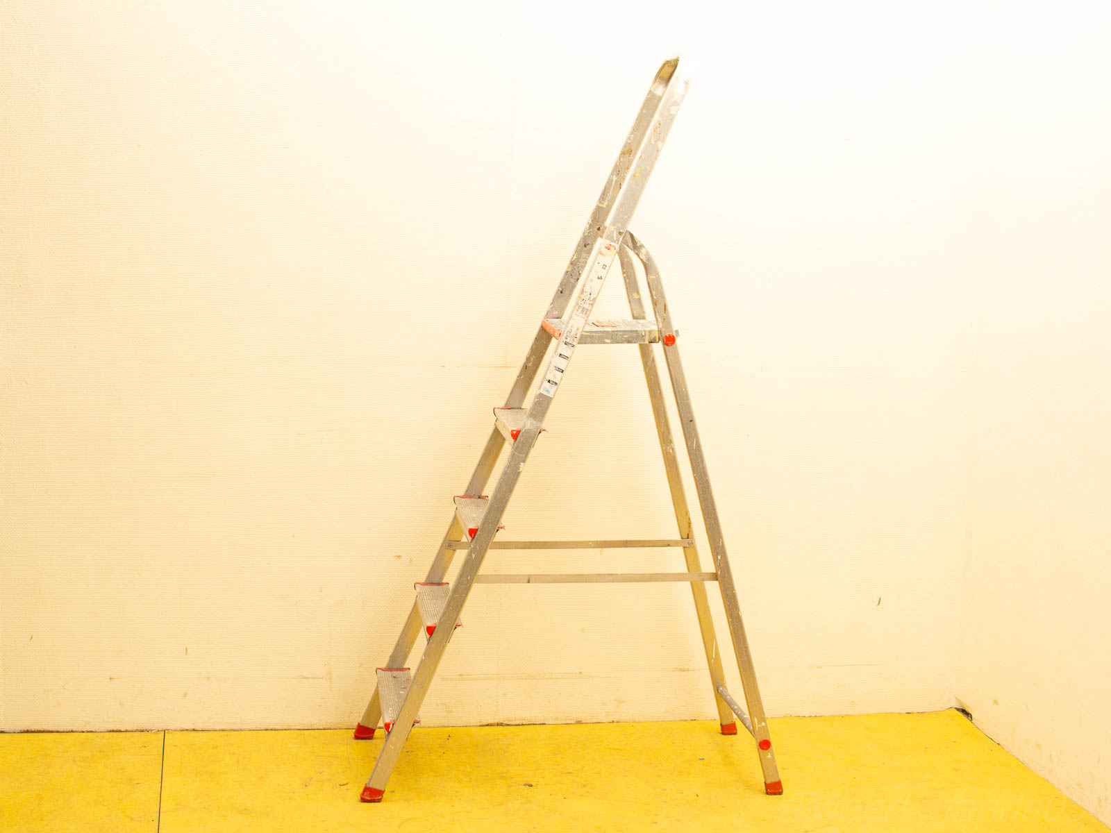 Stylish aluminum step ladder with red edges, ideal for home improvement and safe access.