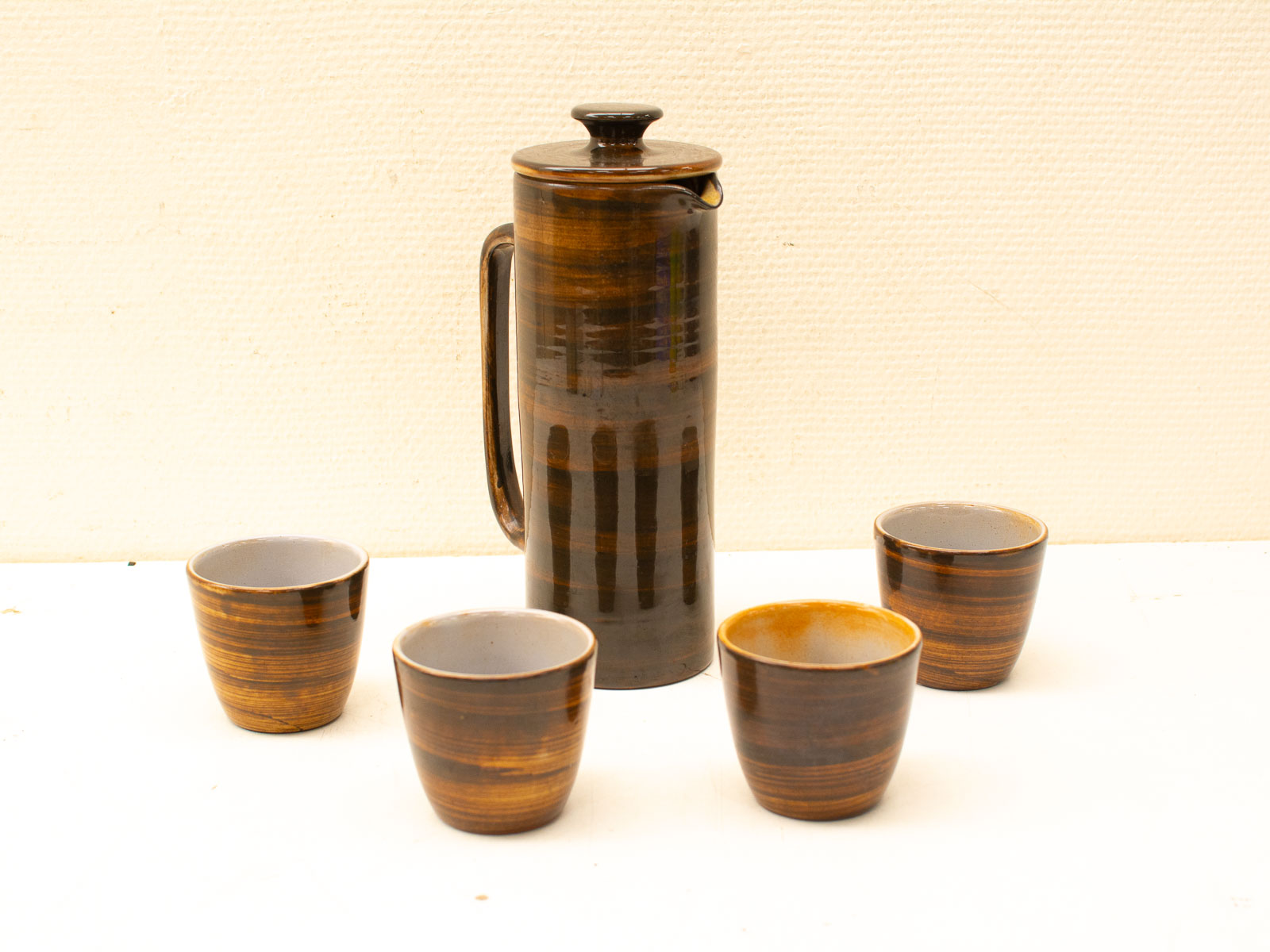 Elegant vintage tea and coffee set with a stylish pot and four matching cups.