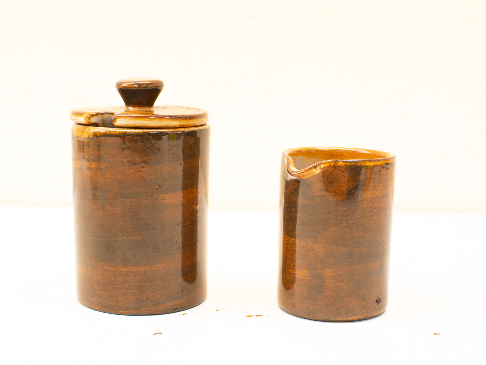 Handmade glossy brown ceramic container and creamer set for stylish kitchen decor.