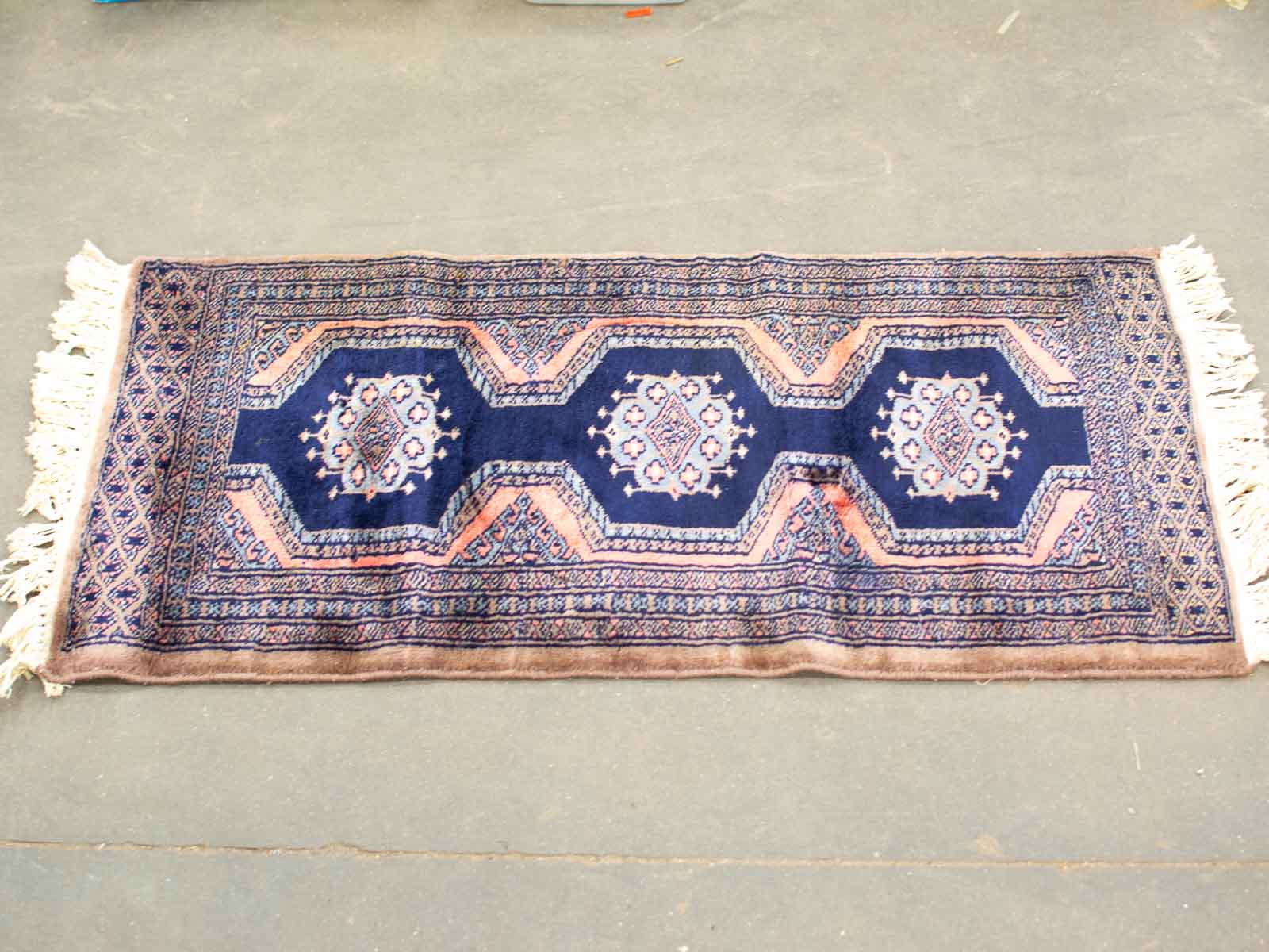 Vintage navy blue handwoven rug with intricate patterns and elegant octagonal designs.