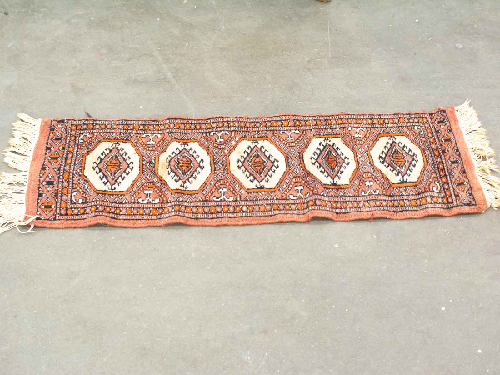 Vintage woven runner rug showcasing intricate diamond patterns in warm, earthy tones.