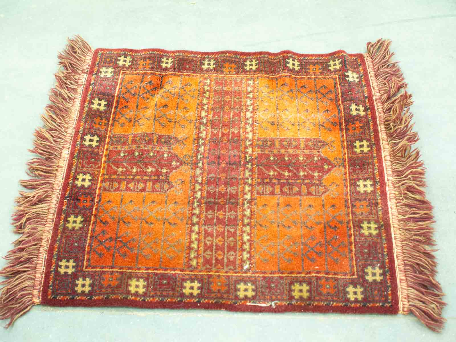 Vibrant orange and red vintage rug with intricate geometric patterns and plush texture.