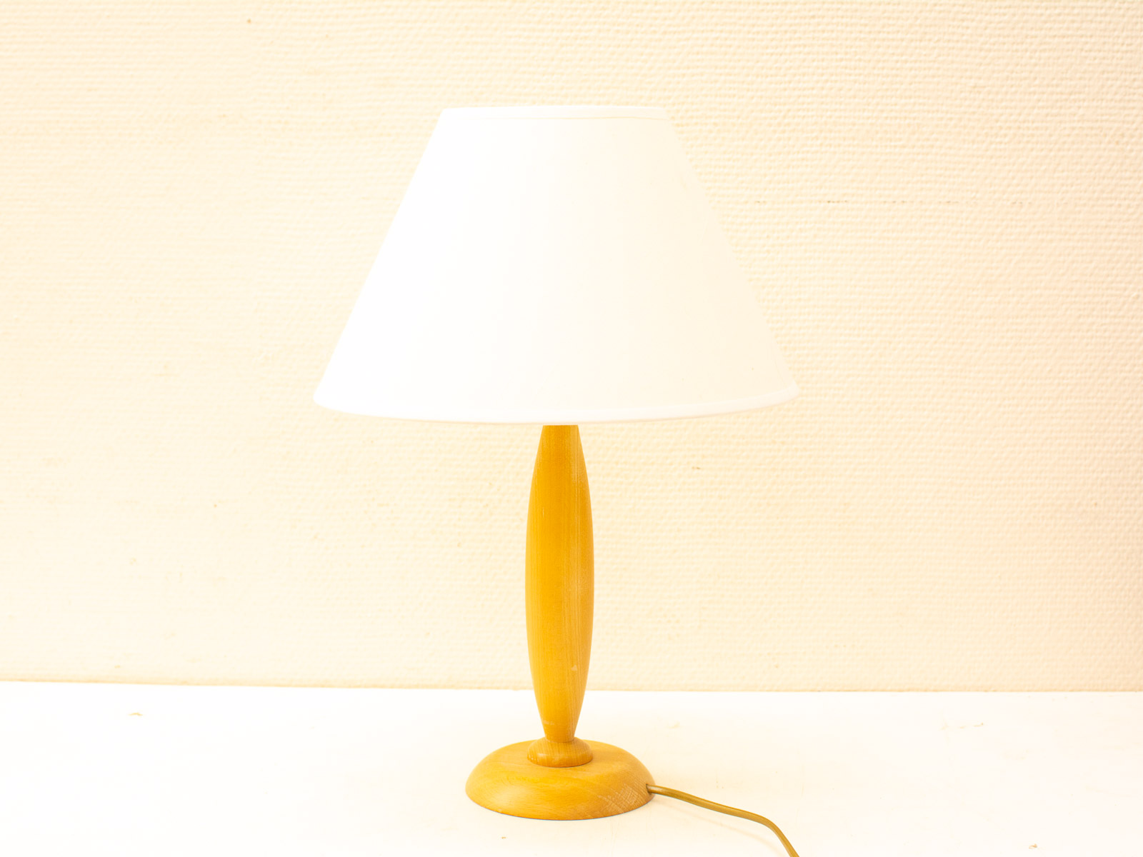 Elegant wooden table lamp with white shade, perfect for warm and inviting home decor.