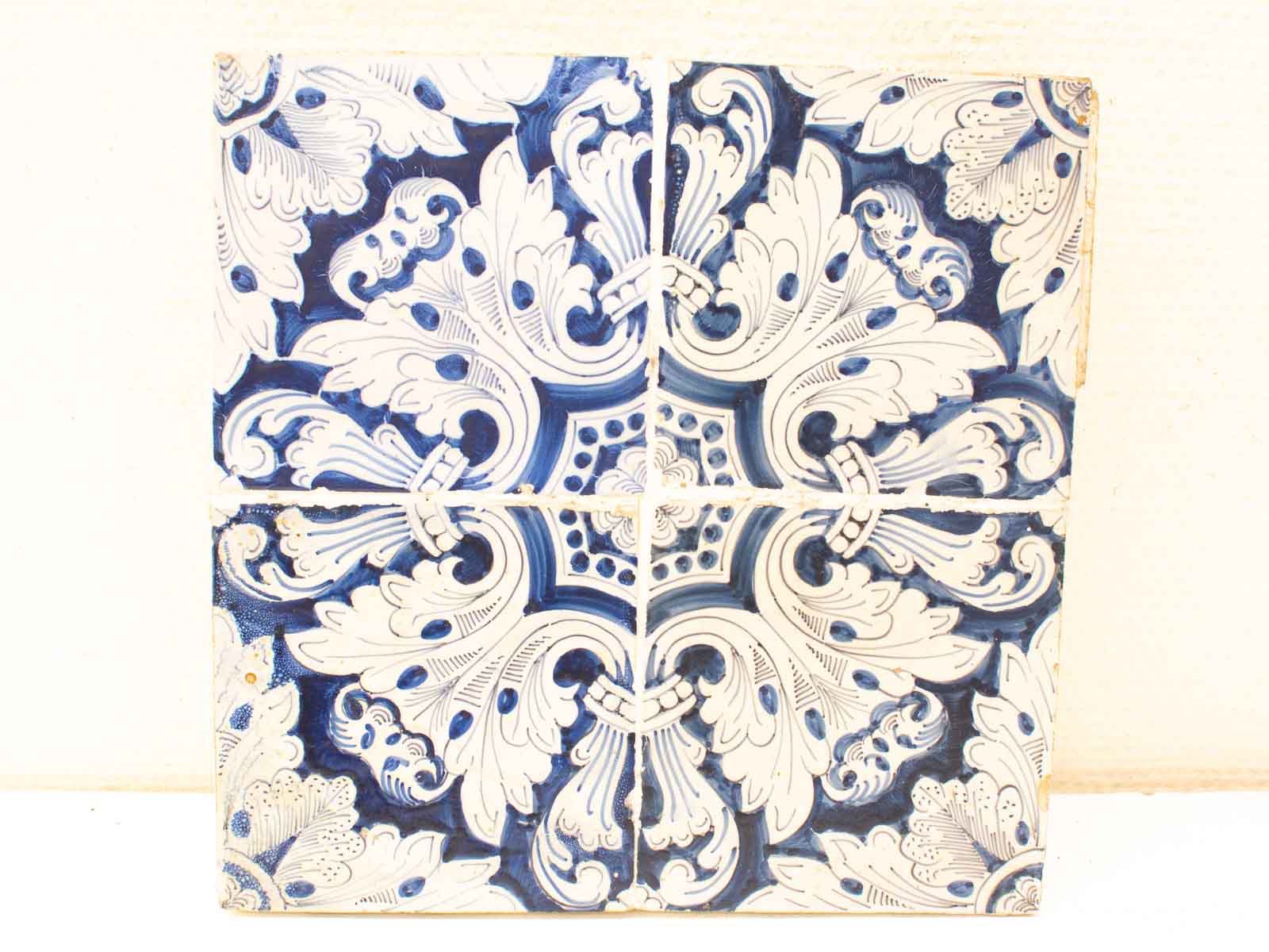 Elegant blue and white decorative tile with intricate floral designs and vintage charm.