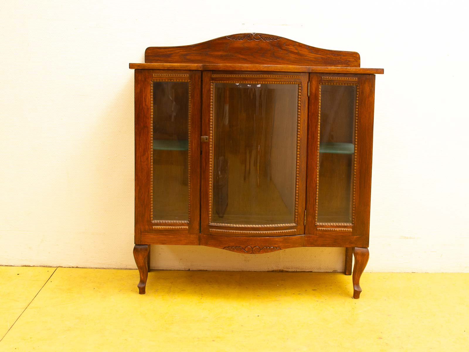 Elegant vintage wooden cabinet with glass doors, perfect for showcasing collectibles and adding charm.