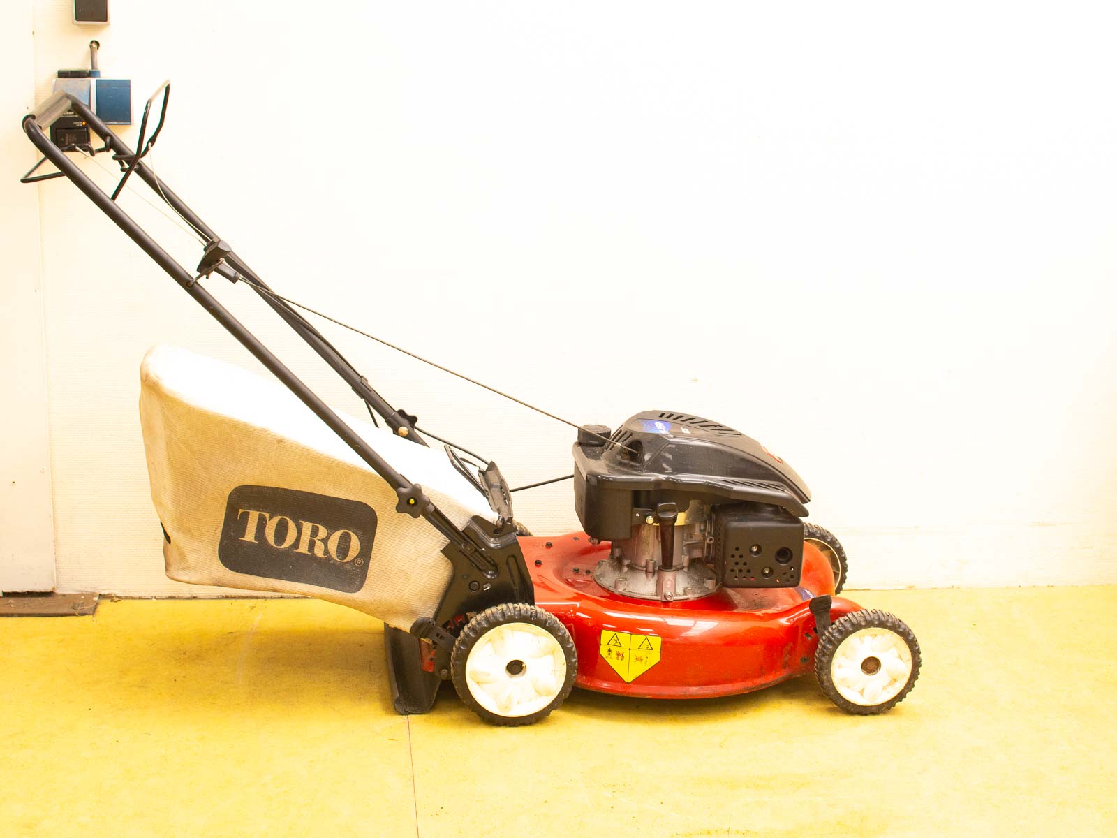 Toro lawn mower in red and black with grass catcher, perfect for efficient lawn care.