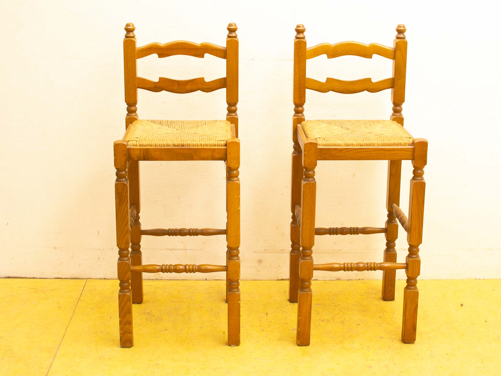 Charming rustic wooden stools with woven straw seats, perfect for inviting kitchens and dining spaces.