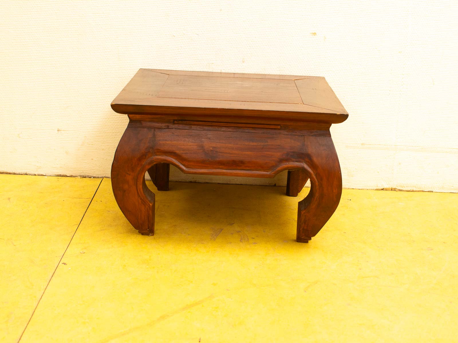 Elegant wooden table with unique curved legs, rounded edges, and rich dark finish. Perfect centerpiece.