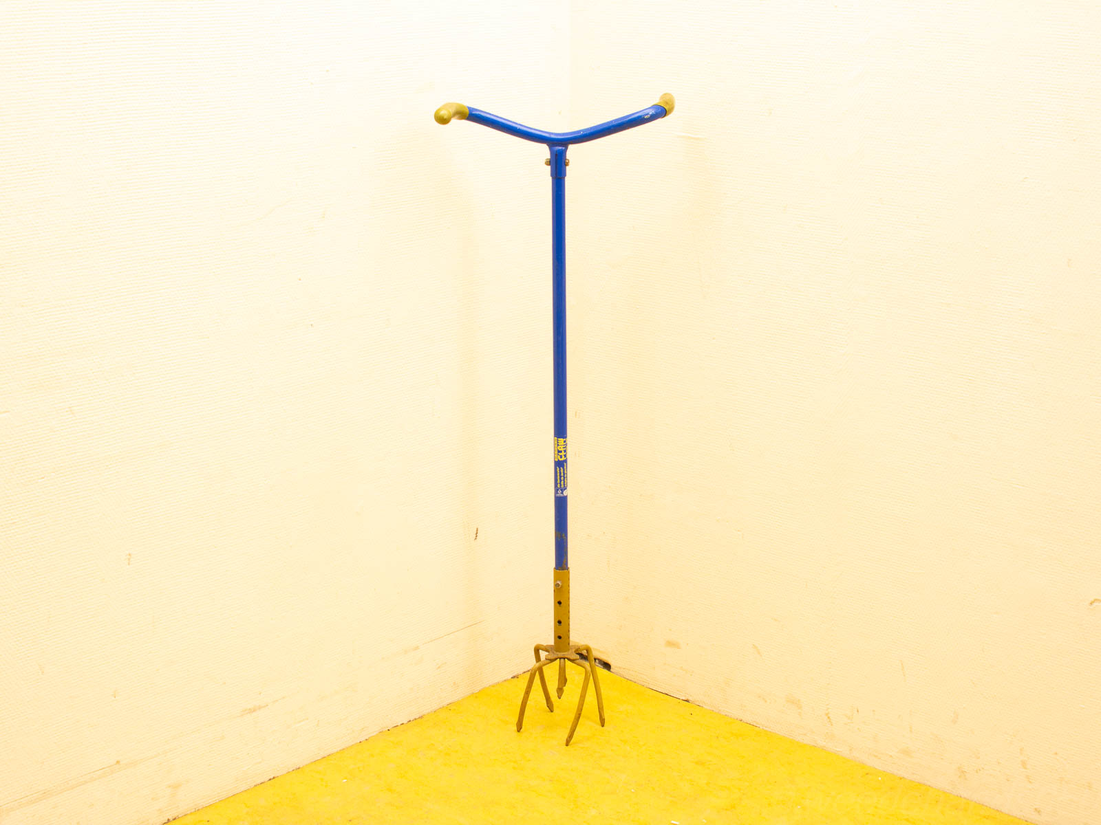 Vintage blue cultivator with yellow grip, perfect for soil aeration and gardening tasks.