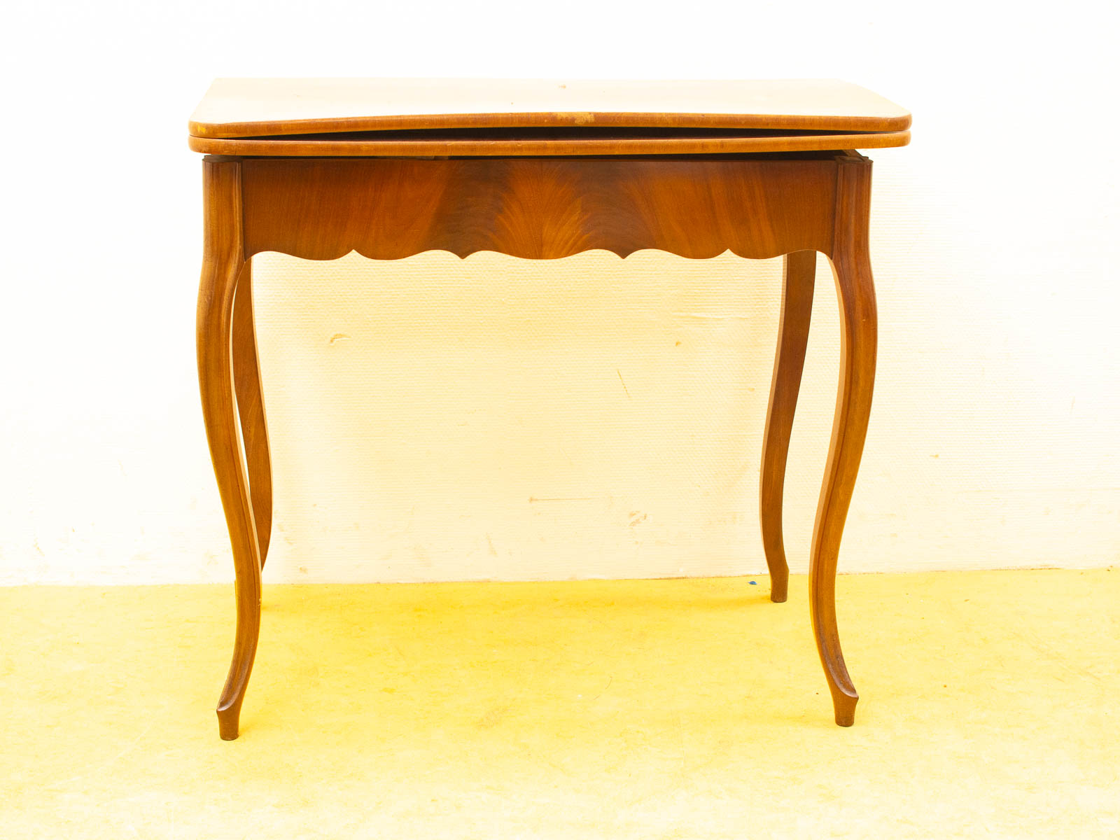 Elegant vintage wooden table with rounded corners, polished finish, and graceful curved legs.