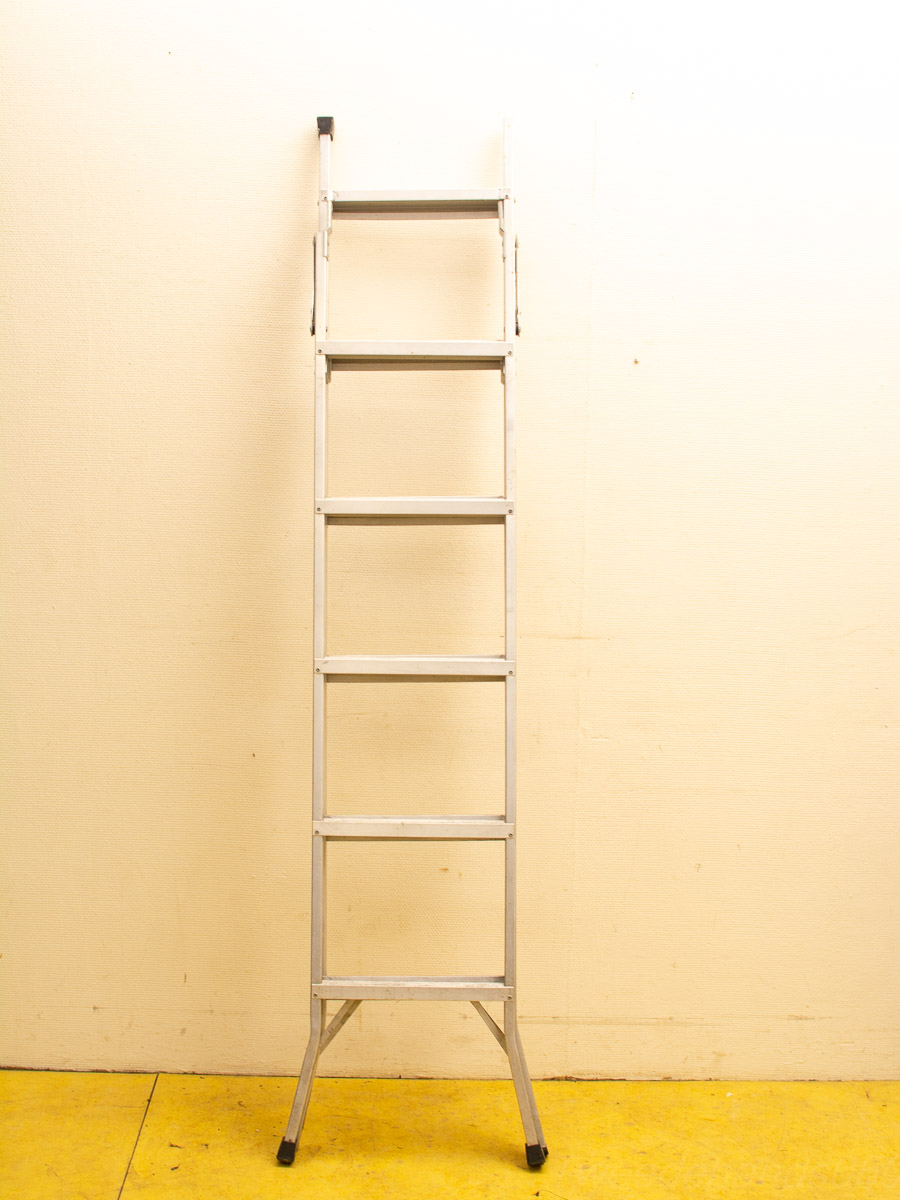 Sturdy aluminum ladder against a cheerful yellow wall, perfect for home improvement tasks.