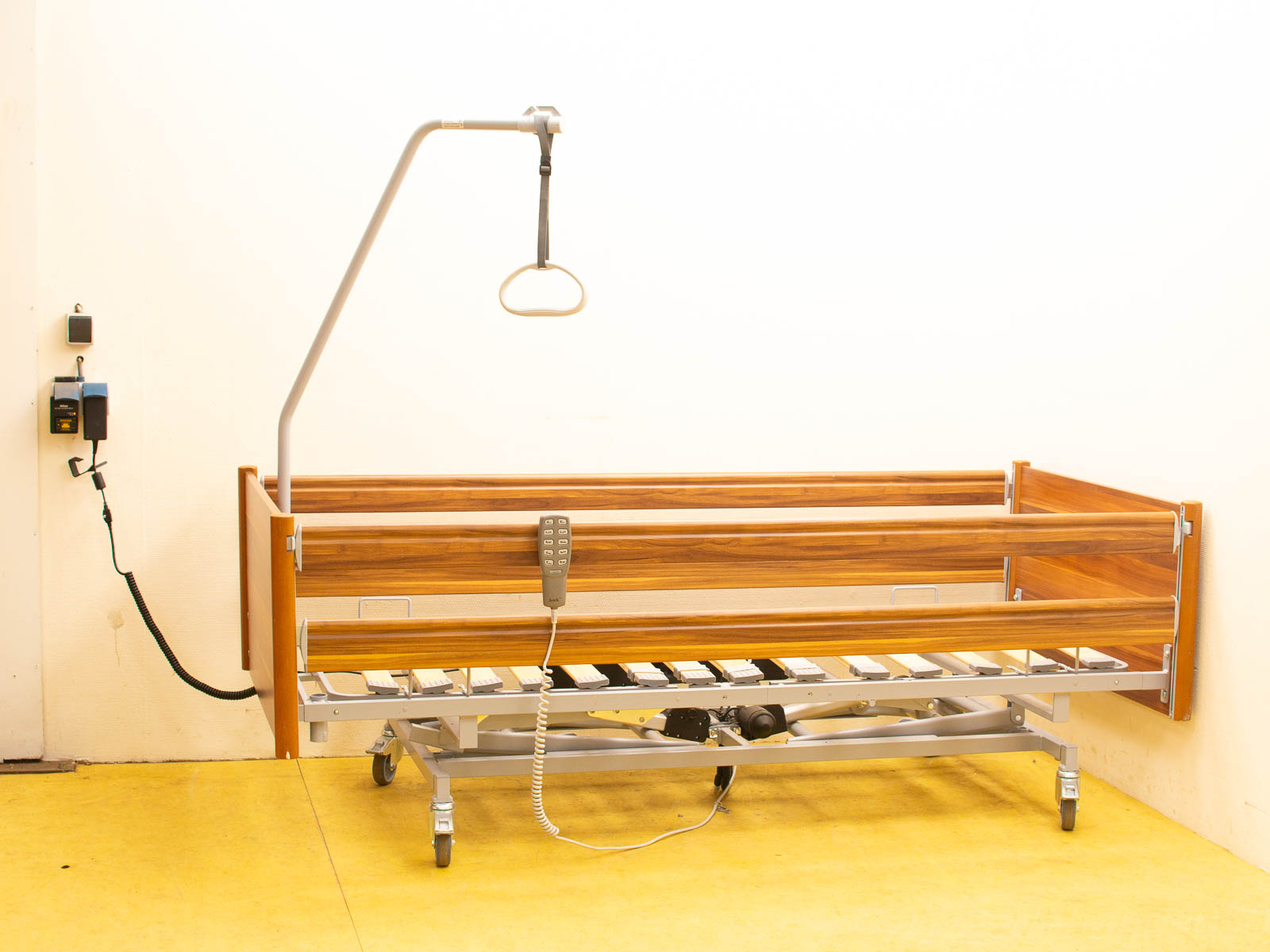 Adjustable vintage hospital bed in metal and wood, designed for patient comfort and mobility.