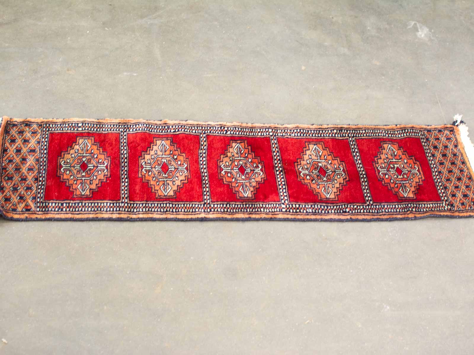 Vibrant red geometric textile with intricate diamond patterns, showcasing traditional craftsmanship and cultural artistry.