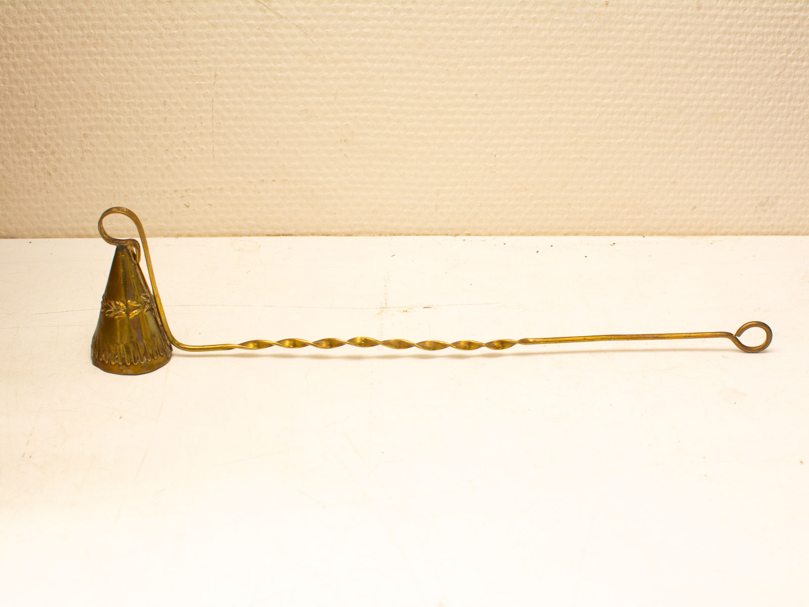 Elegant vintage brass candle snuffer with decorative designs, perfect for antique decor enthusiasts.