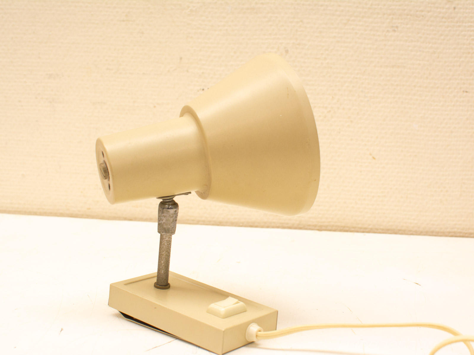 Vintage beige desk lamp with adjustable neck for stylish workspace lighting.