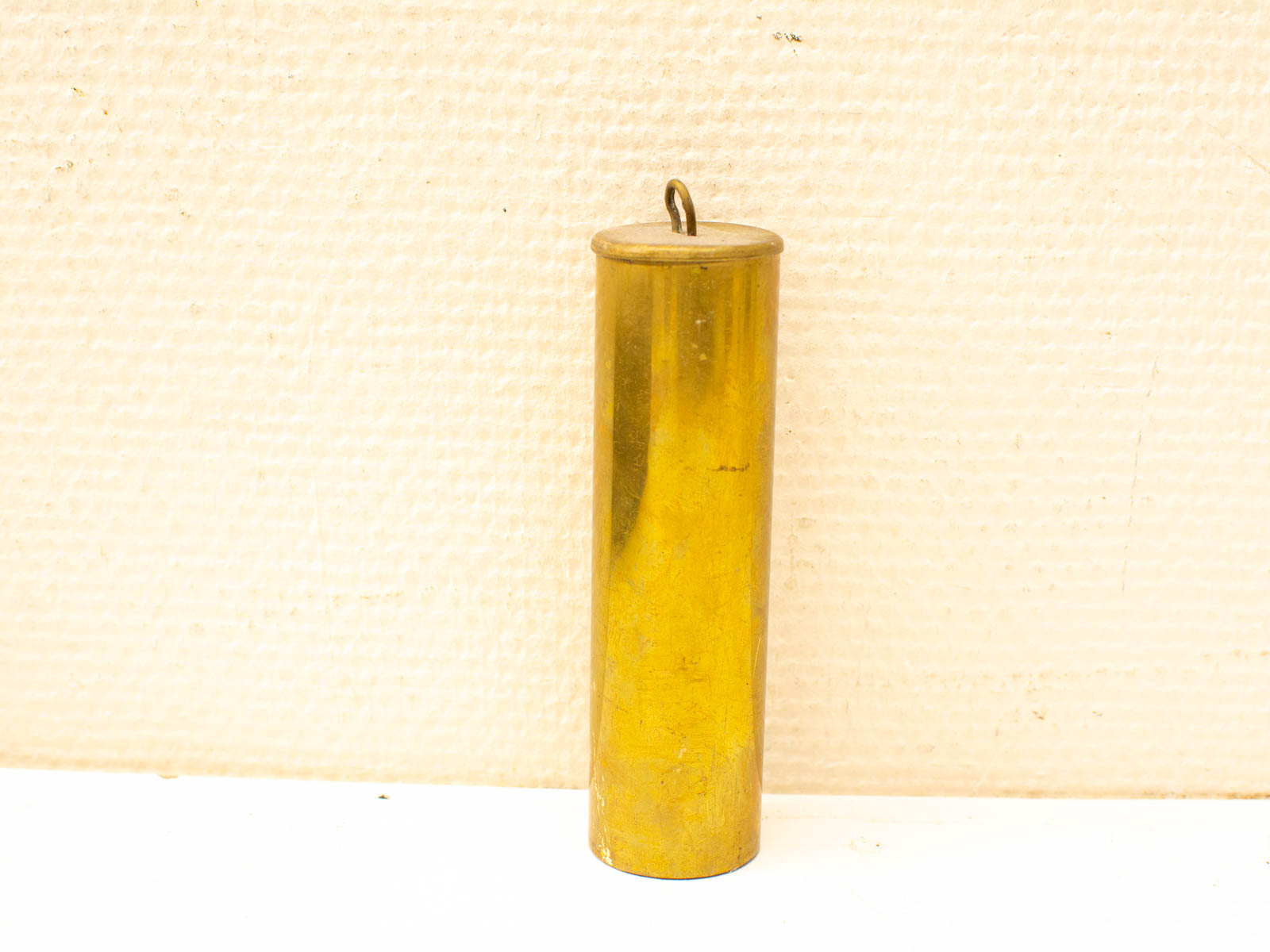 Antique brass cylinder with hook, perfect for decoration or functional use.