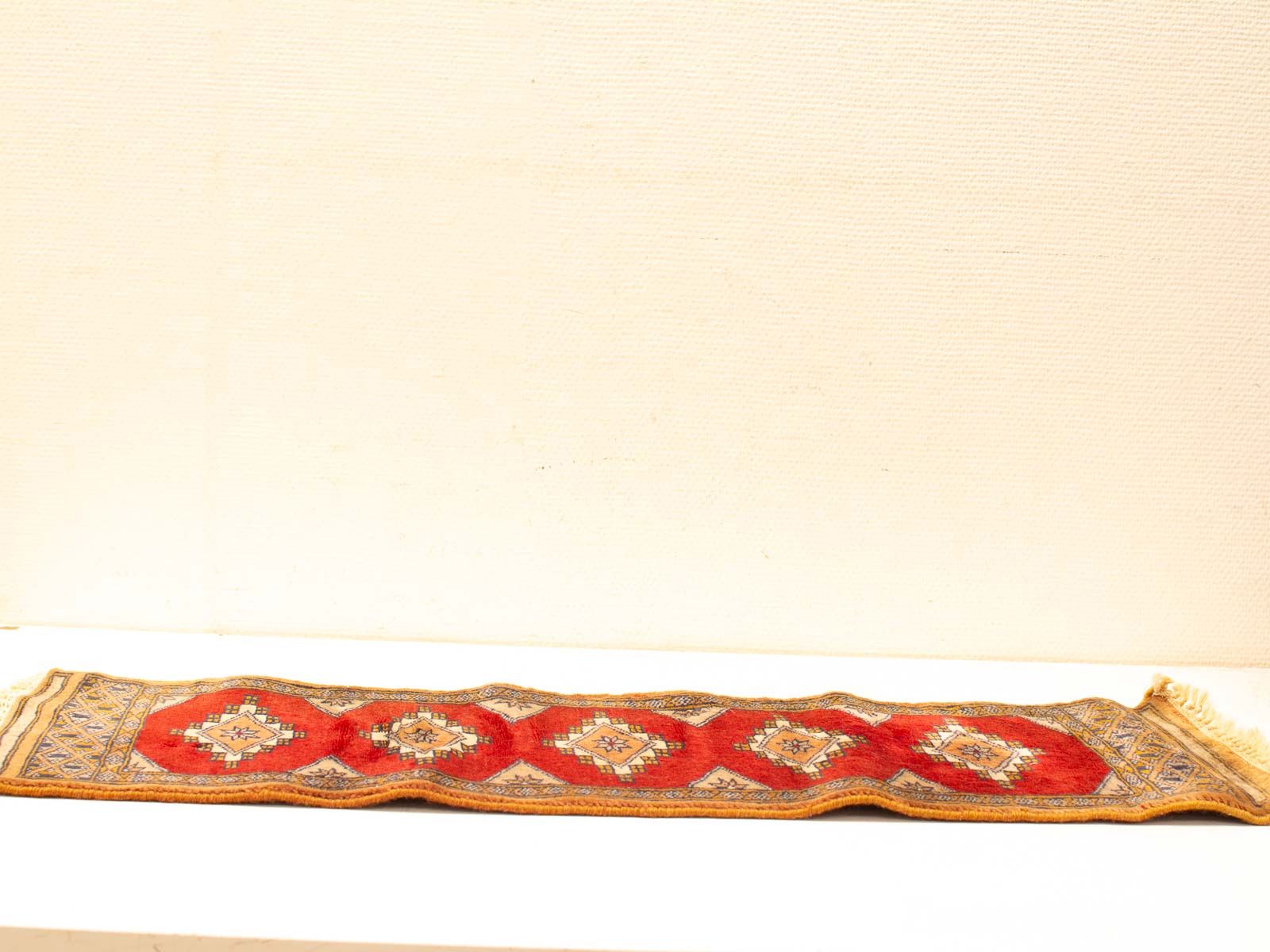 Vibrant red and beige vintage runner with intricate diamond-patterned design for elegant decor.