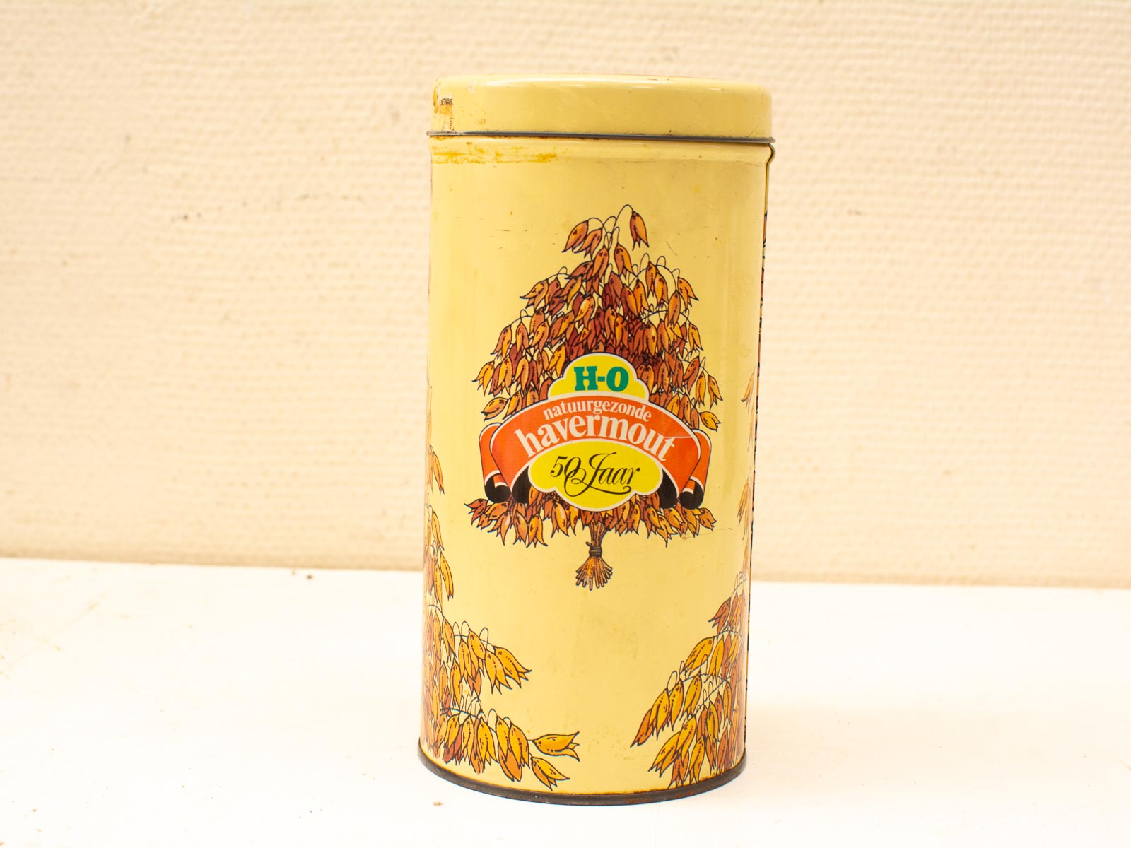 Charming vintage yellow tin canister with tree illustration, labeled H-O havermout (oatmeal).