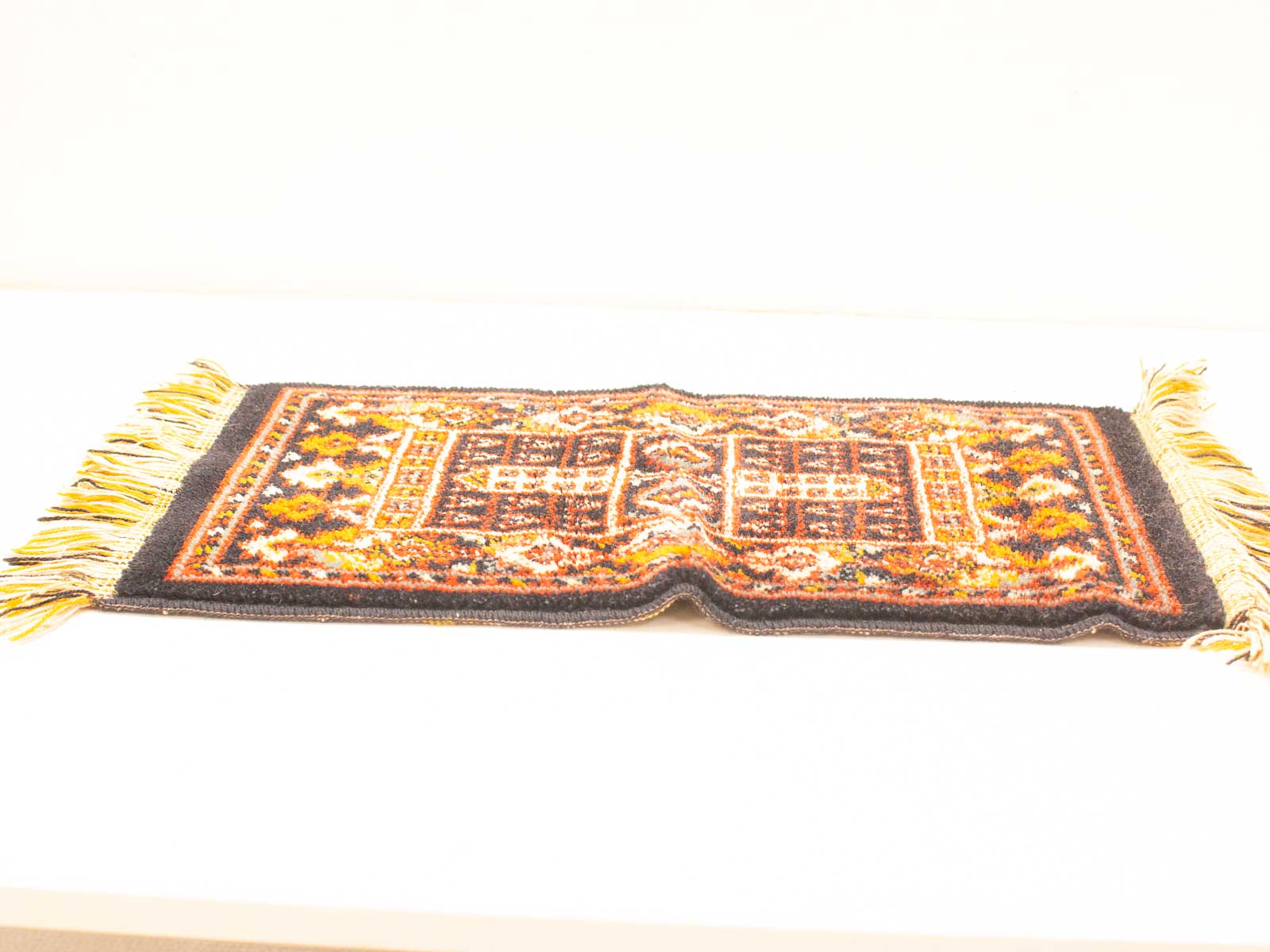 Vibrant vintage rug with intricate geometric patterns in deep reds, oranges, and blacks.