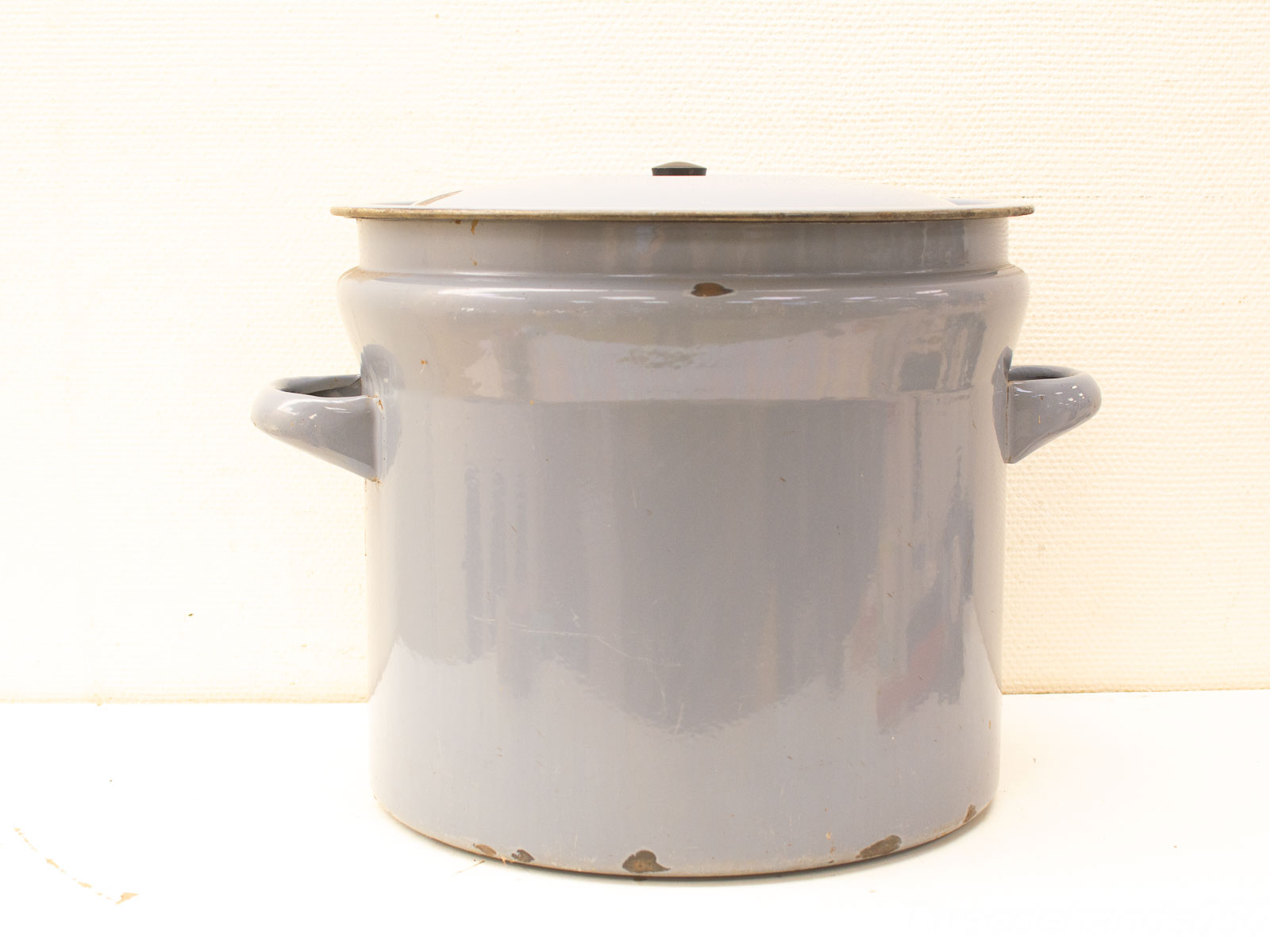 Charming vintage gray enamel cooking pot with lid and sturdy handles, perfect for home cooking.