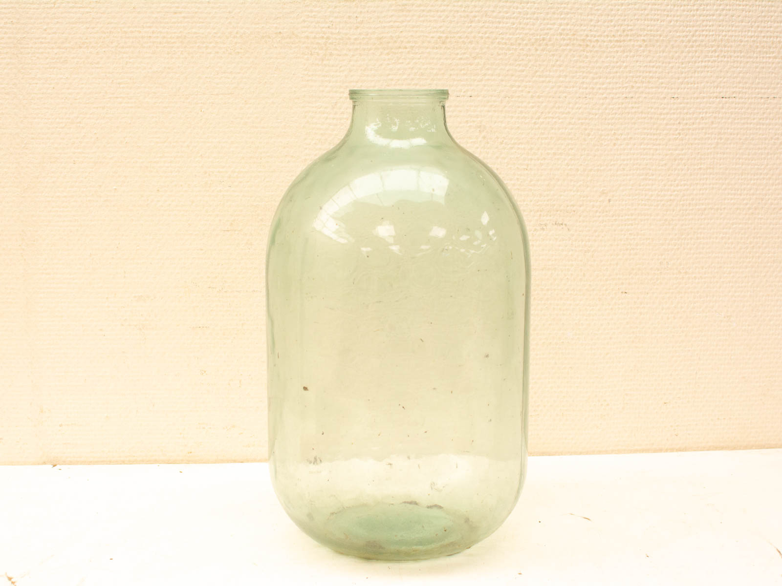 Charming vintage green glass jar with a bulbous shape and rustic character for home decor.