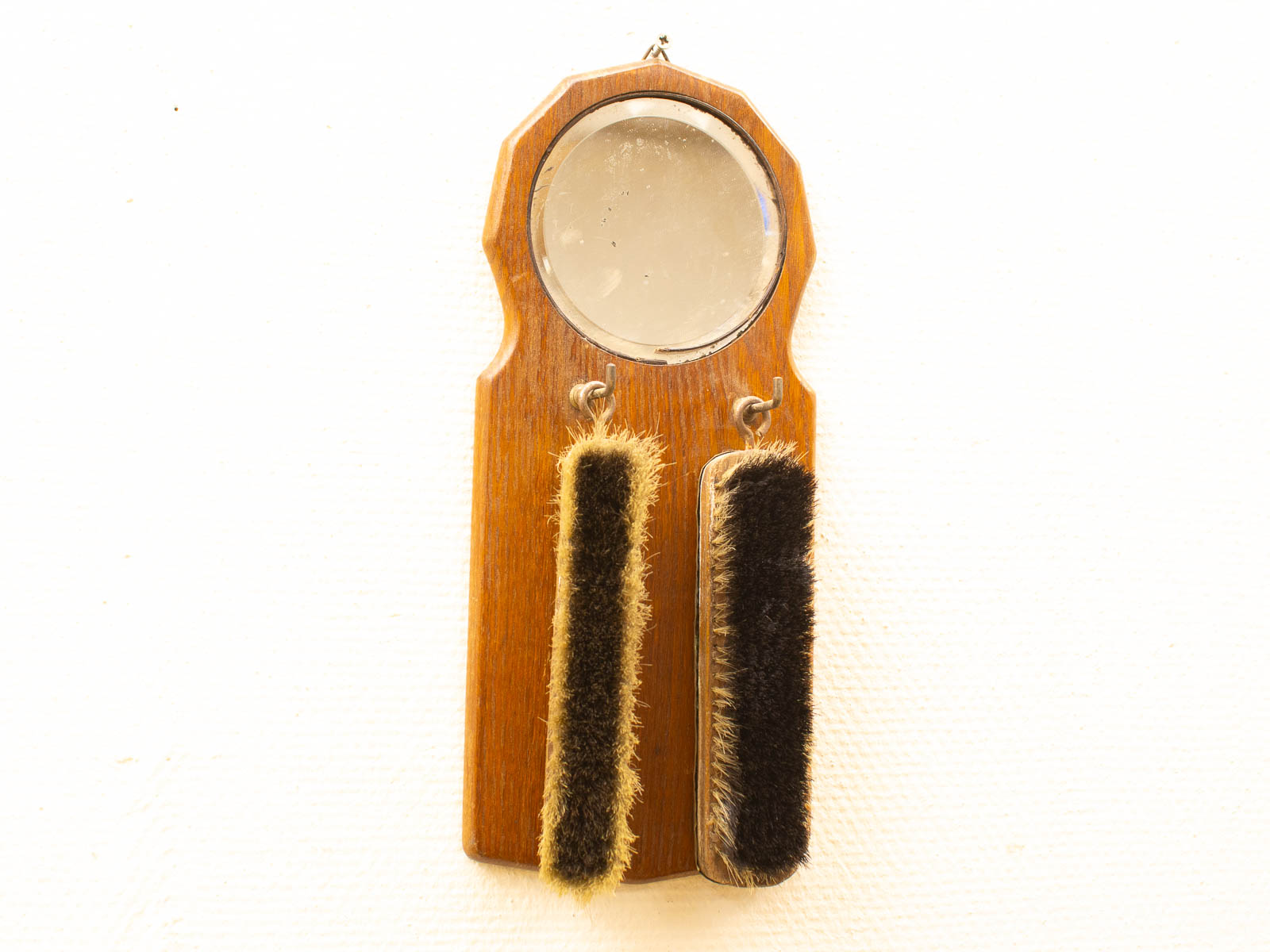 Elegant vintage grooming tool with mirror and contrasting brushes, perfect for collectors and decor.