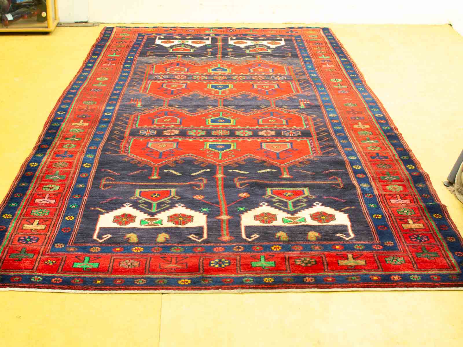 Vivid red geometric rug with intricate patterns, handcrafted artistry for a cultural touch.