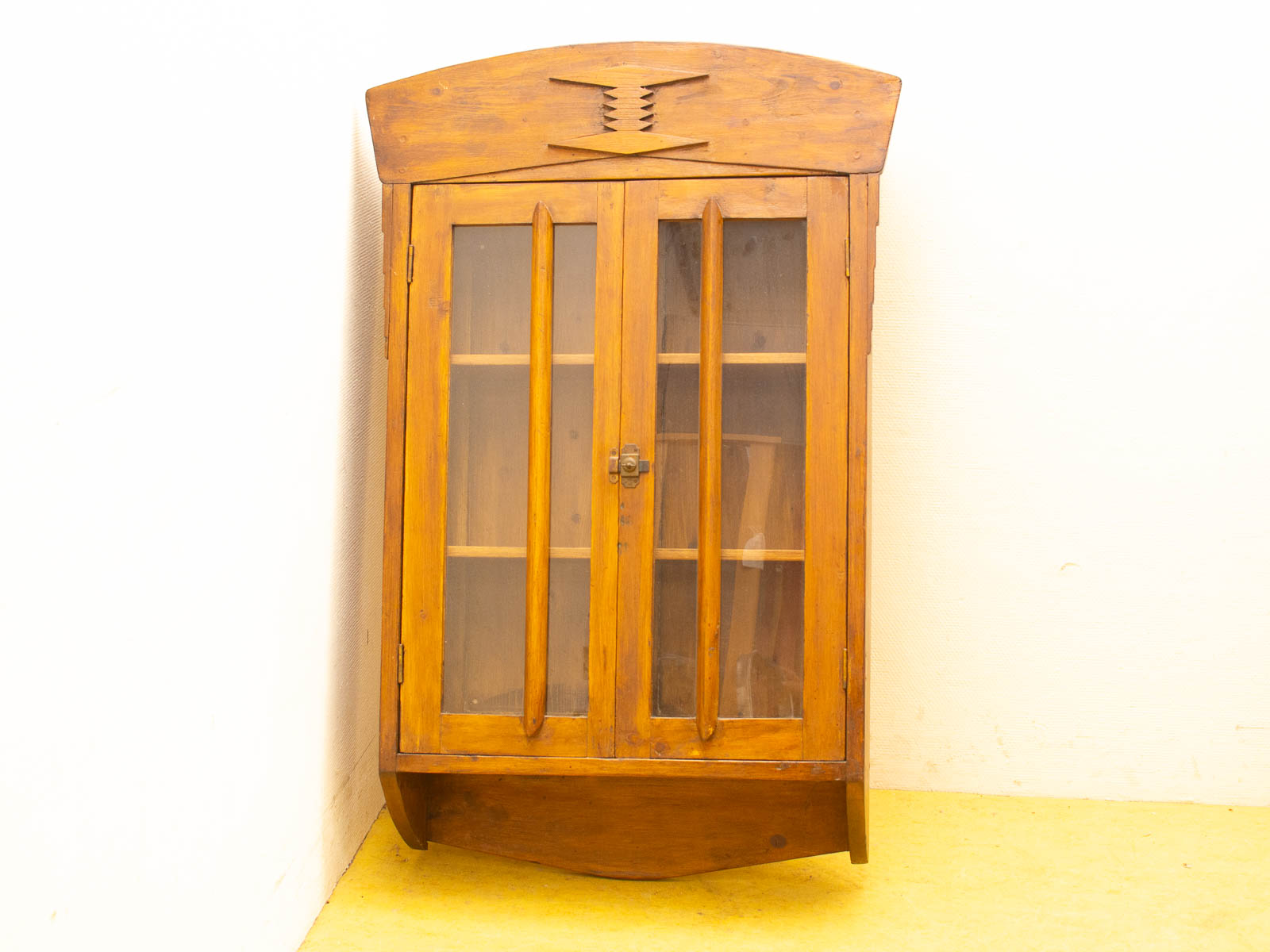 Charming vintage wooden cabinet with glass doors, perfect for displaying collectibles and adding warmth.