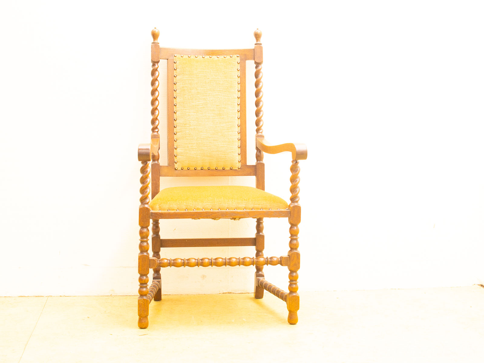 Rustic wooden chair with vibrant gold upholstery and elegant twisted spindle design.