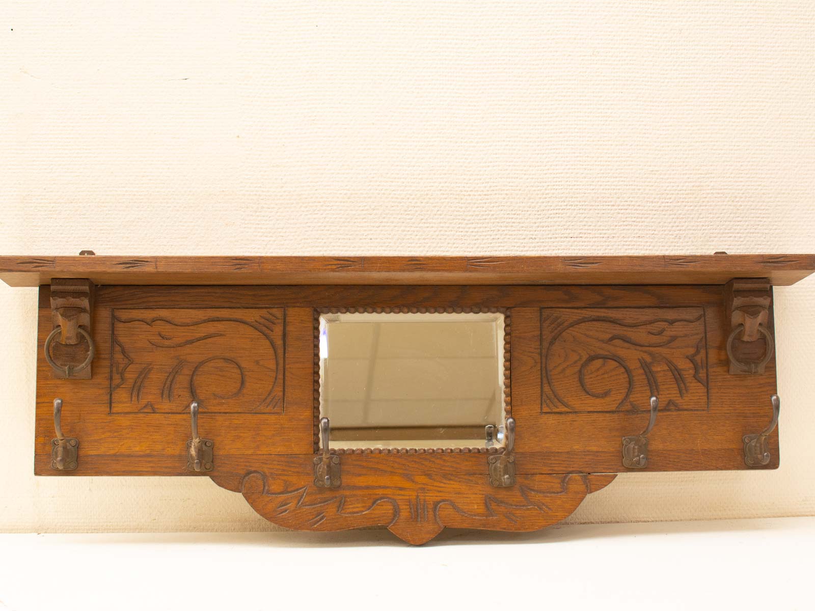 Elegant vintage wall shelf with mirror and hooks, perfect for entryways and stylish storage.