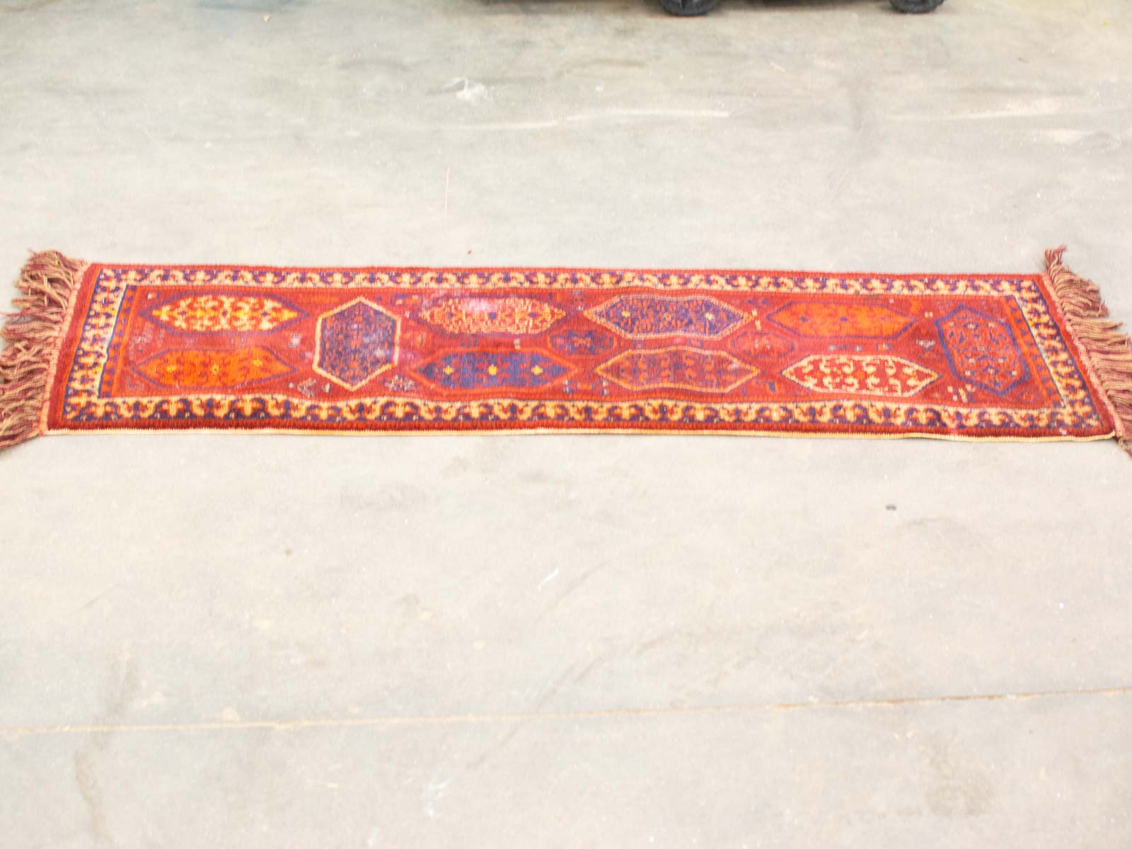 Vintage red and orange geometric rug, perfect for hallways, adding warmth and elegance to your home.